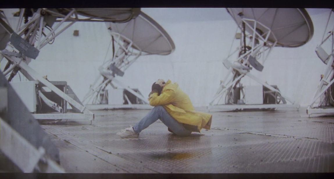 Grace in a curled up position on the rooftop of some building, contemplating on going to the Hail Mary